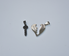 Dos dijes de acero inoxidable de llave negra que encaja en corazón dorado.