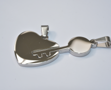 Dos dijes de acero inoxidable de corazón y llave que embonan.