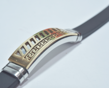 Pulsera negra con dije dorado de rayas y grecas